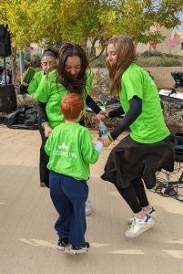 Child dancing with volunteers ילד רוקד עם מתנדבות