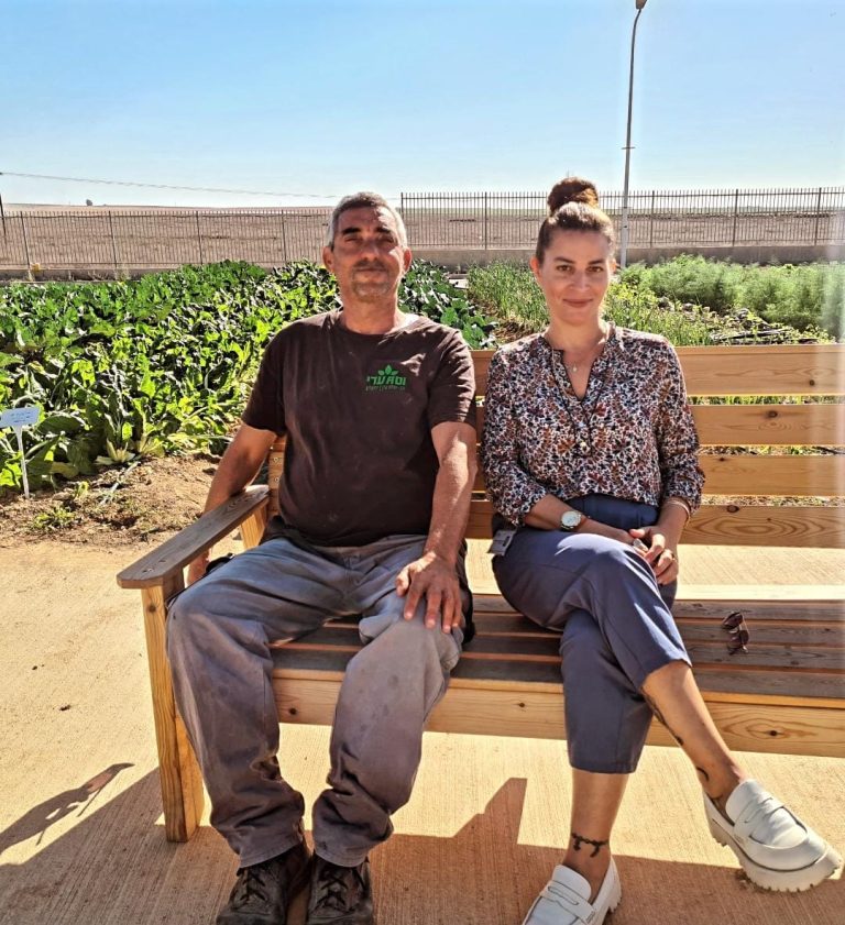 Man and woman sitting on a bench outside איש ואישה יושבים על ספסל בחוץ