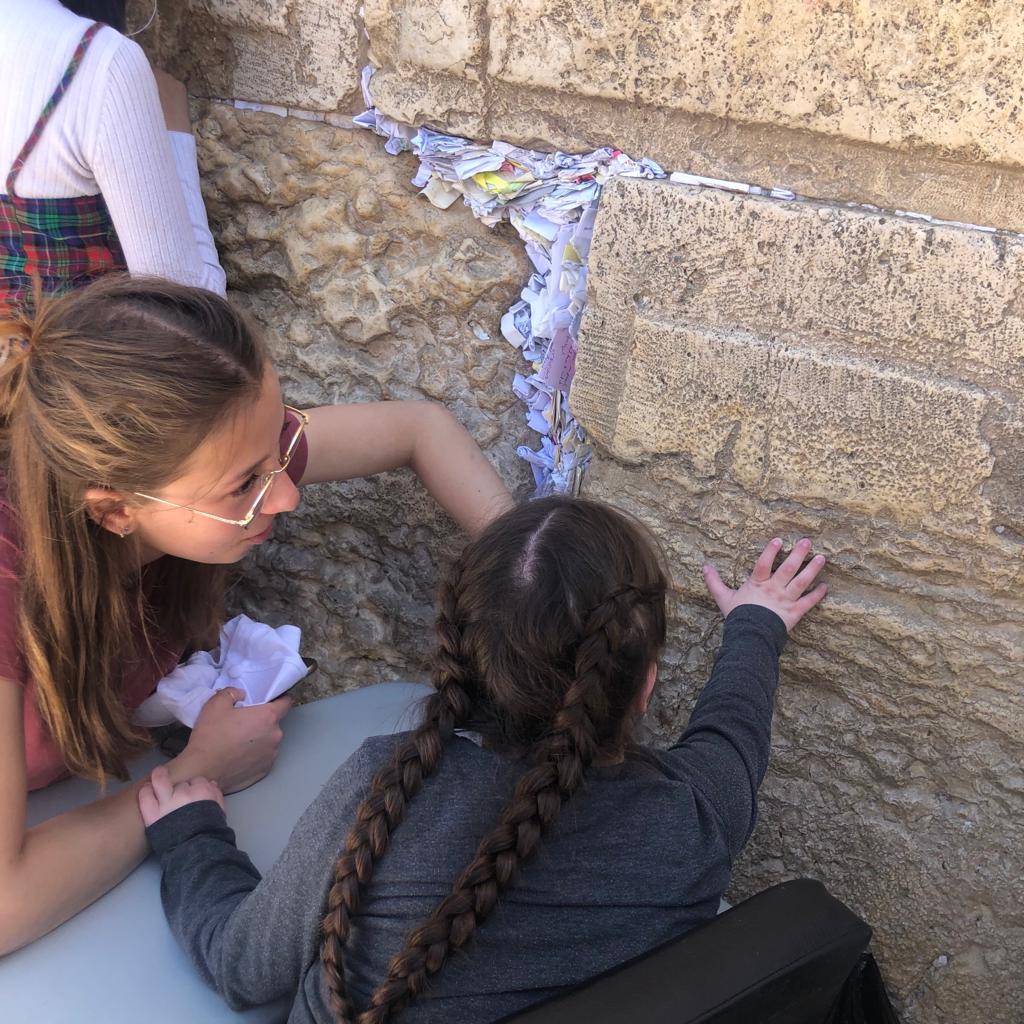 young girl putting note in Kotel